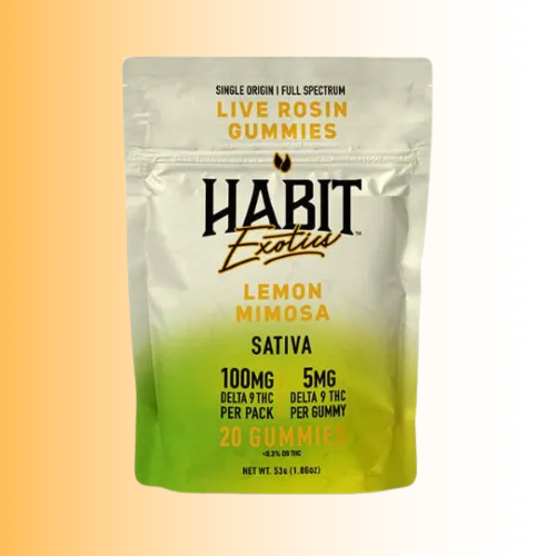A stand-up pouch of Habit Exotica Lemon Mimosa Sativa gummies, featuring a silver-to-yellow gradient top half and a yellow-to-green gradient bottom half, on a warm beige-to-yellow gradient background.