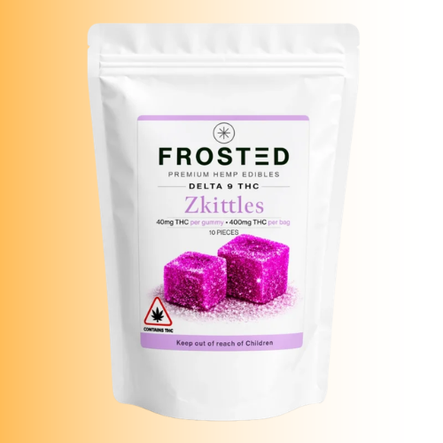 A white stand-up pouch of Frosted Premium Hemp Edibles Delta 9 THC Zkittles, featuring a label with purple accents and an illustration of two pink frosted cube candies, set against a warm yellow-to-white gradient background.