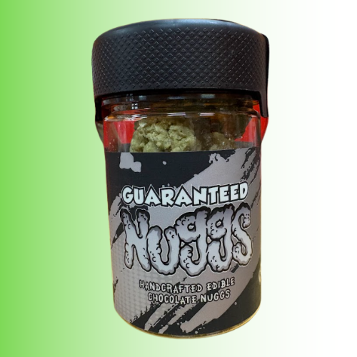 A jar of 'Guaranteed Nuggs' handcrafted edible chocolate nuggs, featuring a black textured lid and a black, gray, and white label, set against a green-to-white gradient background.
