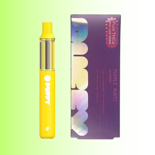 A yellow disposable vape device stands next to its purple packaging box with holographic lettering, set against a light green gradient background.